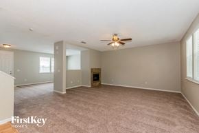 Jacksonville house for rent - A spacious room with a fireplace and a ceiling fan.