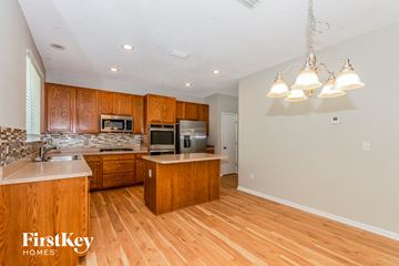 Jacksonville house for rent - A kitchen with wooden cabinets and a countertop with a sink.