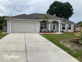 Englewood house for rent - a white house with a driveway and a garage door
