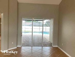 Englewood house for rent - an empty living room with sliding glass doors to a pool