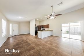 Glendale house for rent - an empty living room with a kitchen and a ceiling fan
