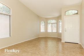 Laveen house for rent - an empty living room with a white door and three windows