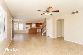 Laveen house for rent - an empty living room with a ceiling fan and a kitchen