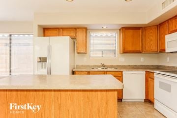 Laveen house for rent - a kitchen with white appliances and wooden cabinets