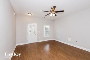 Monroe house for rent - a living room with white walls and a ceiling fan