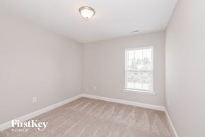 Monroe house for rent - a bedroom with a carpeted floor and a window
