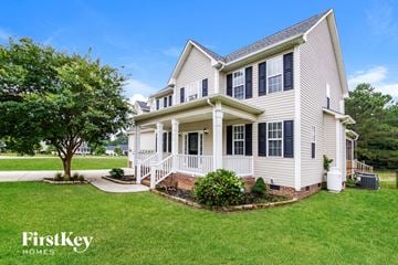 Raleigh house for rent - a white house with a porch and a tree in the yard