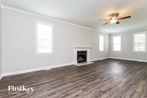 Raleigh house for rent - a living room with a fireplace and a ceiling fan