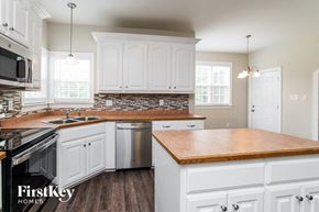 Raleigh house for rent - an updated kitchen with white cabinets and wood counter tops