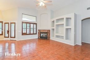 Tucson house for rent - A living room with a fireplace and a fan.
