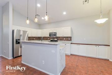Tucson house for rent - A kitchen with a refrigerator, sink, and cabinets.
