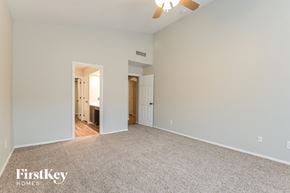 Tucson house for rent - A spacious room with a carpeted floor and a ceiling fan.