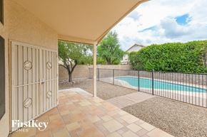 Tucson house for rent - A patio with a pool and a fence.