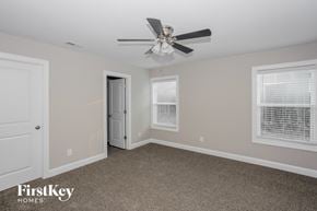 Kannapolis house for rent - a bedroom with a ceiling fan and a door to a closet