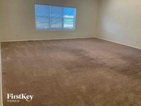 Colorado Springs house for rent - an empty room with a carpeted floor and a window