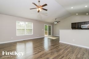 Moscow Mills house for rent - A spacious room with a ceiling fan and wooden flooring.