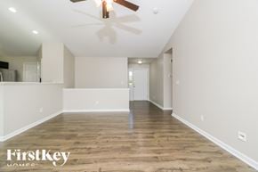 Moscow Mills house for rent - A spacious room with wooden floors and a ceiling fan.