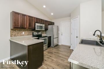 Moscow Mills house for rent - A kitchen with brown cabinets and a granite countertop.