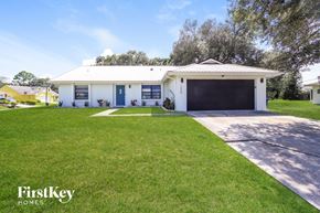 Palm Bay house for rent - A white house with a garage is for sale.