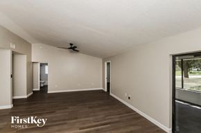 Palm Bay house for rent - A spacious room with wooden floors and a ceiling fan.