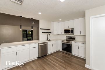 Palm Bay house for rent - A modern kitchen with white cabinets and stainless steel appliances.