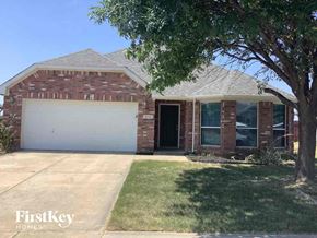 Rhome house for rent - a brick house with a white garage door and a tree