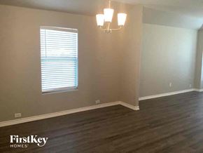 Rhome house for rent - a living room with wooden floors and a window and a chandelier