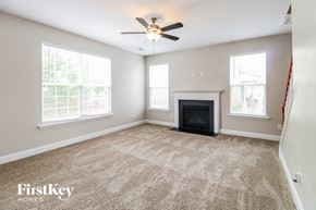 Clemmons house for rent - an empty living room with a fireplace and a ceiling fan