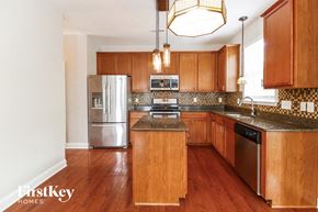 Clemmons house for rent - a kitchen with wooden cabinets and stainless steel appliances