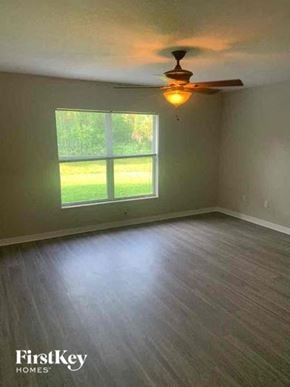 North Port house for rent - A room with a ceiling fan and a window overlooking a green lawn.