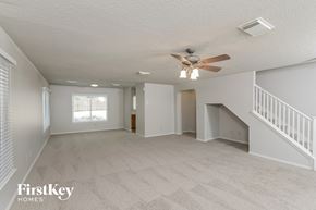 San Antonio house for rent - A spacious room with a fan and carpeted floor.