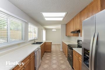 San Antonio house for rent - A kitchen with wooden cabinets and a stainless steel refrigerator.