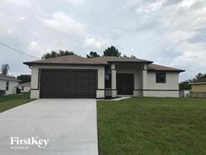 Lehigh Acres house for rent - a house with a driveway and a garage door