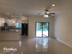 Lehigh Acres house for rent - a large empty kitchen with a ceiling fan