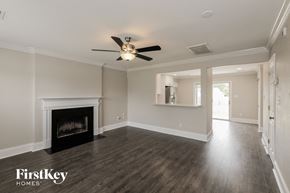 Indian Trail house for rent - A spacious room with a fireplace and a ceiling fan.