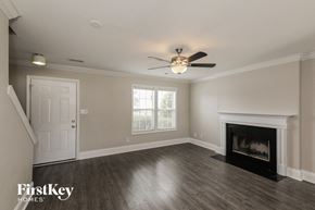 Indian Trail house for rent - A spacious living room with a fireplace and a ceiling fan.
