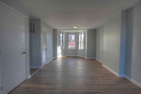 Baltimore apartment for rent - a living room with white walls and a wood floor
