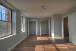 Baltimore apartment for rent - an empty room with a hard wood floor and three doors
