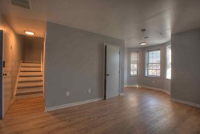 Baltimore apartment for rent - an empty living room with wood floors and a staircase