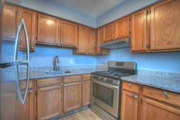 Baltimore apartment for rent - a kitchen with wooden cabinets and stainless steel appliances