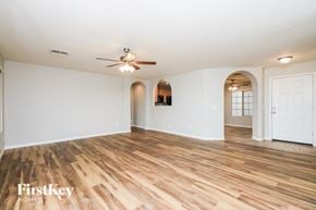 San Tan Valley house for rent - A room with wooden floors and a ceiling fan.