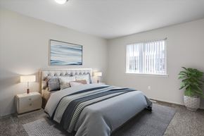 Madison Heights apartment for rent - A bedroom with a large bed and a painting on the wall.