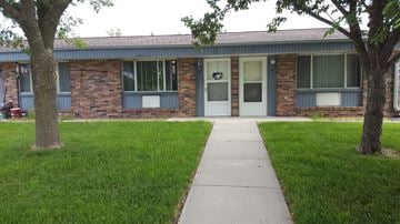 Minden apartment for rent - the front of a brick building with a sidewalk and grass