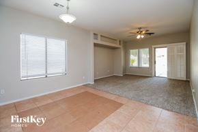 San Tan Valley house for rent - an empty living room with a ceiling fan and a door to a patio