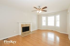 Winder house for rent - A spacious room with a fireplace and a ceiling fan.