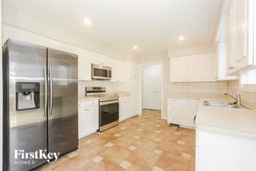 Winder house for rent - A kitchen with a stainless steel refrigerator and white cabinets.