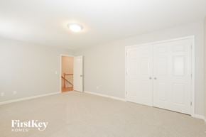 Winder house for rent - A white bedroom with a doorway leading to another room.