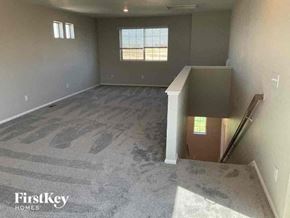 Commerce City house for rent - an empty room with a staircase and a box on the floor
