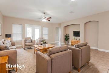 Fleming Island house for rent - A living room with a beige carpet and furniture.