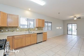 Tucson house for rent - a kitchen and living room with wood cabinets and a sink